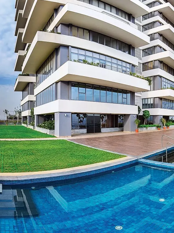 Infinity-edge pool below a white high-rise tower at The Promont by Tata Housing, Bengaluru